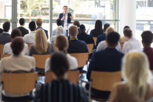 Conference Speaker in Front of Glass Wall